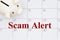 Scam Alert message with piggy bank on a calendar