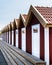 Scandinavian architecture with a row of red pitched summerhouses. Nordic typical architectural buildings in Fotö hamn