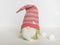 Scandinavian gnome in green clothes and a striped hat on a white background