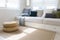 Scandinavian home interior of living room with cozy white sofa and rattan carpet.