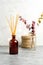 Scandinavian hygge style, home interior - aroma diffuser with wooden sticks, straw basket, dried eucalyptus branches