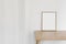 Scandinavian interior. Minimal artistic composition. Blank vertical wooden picture frame mockup on wooden table, desk