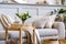 Scandinavian living room interior with design grey sofa, wooden coffee table, plants, shelf, spring flowers in vase, decoration.