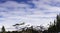 Scandinavian mountain range covered by ice and snow, frozen lake, blue skies, pine forest