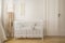 Scandinavian nursery with white wooden crib, real photo with copy space