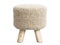 Scandinavian pouf with a knitted seat and wooden legs. 3d render