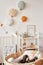 Scandinavian style white interior children& x27; Baby cot with canopy. Wooden shelves and toys. Wicker cradle