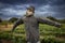 Scarecrow with a scary look at a farm with storm clouds