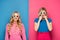 Scared blonde sisters in 3d glasses on blue and pink background