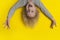 Scared boy with blond long hair hangs upside down and shouts