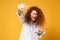 Scared displeased young redhead woman girl in casual white shirt posing isolated on yellow orange background. People