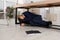 Scared man hiding under office desk during earthquake