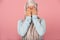 Scared muslim girl in hijab closing eyes, isolated on pink