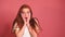 Scared shocked redhaired ginger woman in pink studio background