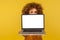 Scared shocked woman with curly hair peeking from behind laptop blank screen with frightened worry eyes