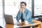 Scared! Side view portrait of emotional nervous young businessman in blue jeans shirt are sitting in cafe, working onlone and nail