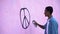 Scared teenager drawing peace symbol on wall with spray paint, stop racism