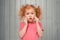 Scared timid redhead little girl in casual pink t shirt, looking frightened and anxious, feeling nervous and terrified