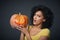 Scared woman holding Halloween pumpkin