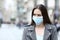 Scared woman with protective mask avoiding contagion on street