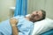 Scared and worried man hospitalized - attractive injured man lying on hospital bed receiving treatment feeling sick after