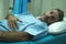 scared and worried man hospitalized - attractive injured man lying on hospital bed receiving treatment feeling sick and unwell