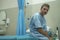 Scared and worried man hospitalized - attractive injured man sitting on hospital bed receiving treatment feeling sick and unwell
