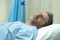 Scared and worried man in pain at hospital room - attractive injured man lying on bed suffering painful problem sick and stressed