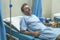 Scared and worried man in pain at hospital room - attractive injured man lying on bed suffering painful problem sick and stressed