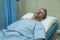 Scared and worried man in pain at hospital room - attractive injured man lying on bed suffering painful problem sick and stressed