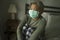 Scared and worried middle aged woman 50s with grey hair and protective mask during covid-19 virus crisis home lockdown quarantine