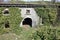 Scary access portal, arched to enter the Fort Bastion of Fosdinovo, a fortress taken by nature and wild vegetation