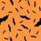 Scary black bats are flocking, isolated on an orange Halloween vector background. Illustration of nocturnal creatures-bats.