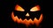 Scary carved halloween pumpkin in hot burning hell fire flames. The big helloween pumpkin has a mad face with glowing