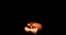 Scary carved halloween pumpkin in hot burning hell fire flames. The big helloween pumpkin has a mad face with glowing