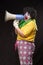 Scary clown shouting into a megaphone on a black background