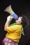 Scary clown shouting into a megaphone on a black background