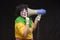 Scary clown shouting into a megaphone on a black background