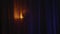 scary creepy woman silhouette with burning candle moving behind curtain in dark