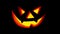 Scary face on blinking on black background. Jack-o-lantern glowing in the dark. Halloween concept