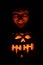 Scary face lit by Halloween pumpkin. Evil Laughing. Human Face