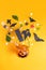 Scary face pumpkin vase with yellow flowers bouquet and halloin props