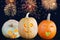 Scary and fun Halloween pumpkins on the background of the night sky and fireworks