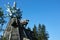 Scary ghost sculptures on roof of mill by blue sky background