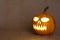 Scary glowing pumpkin face. Scary Halloween pumpkin on a burlap background.