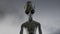 Scary gray alien stands and looks blinking on a dark smoky background. UFO futuristic concept. 3D rendering.