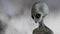 Scary gray alien walks and looks blinking on a dark smoky background. UFO futuristic concept. 3D rendering