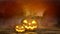 Scary halloween background with grinning pumpkins and tombstone in background