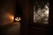 Scary Halloween pumpkin in the mystical house window at night or halloween pumpkin in night on room with blue window. Symbol of