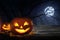 Scary Jack O Lantern pumpkins under moon on Halloween. Space for text